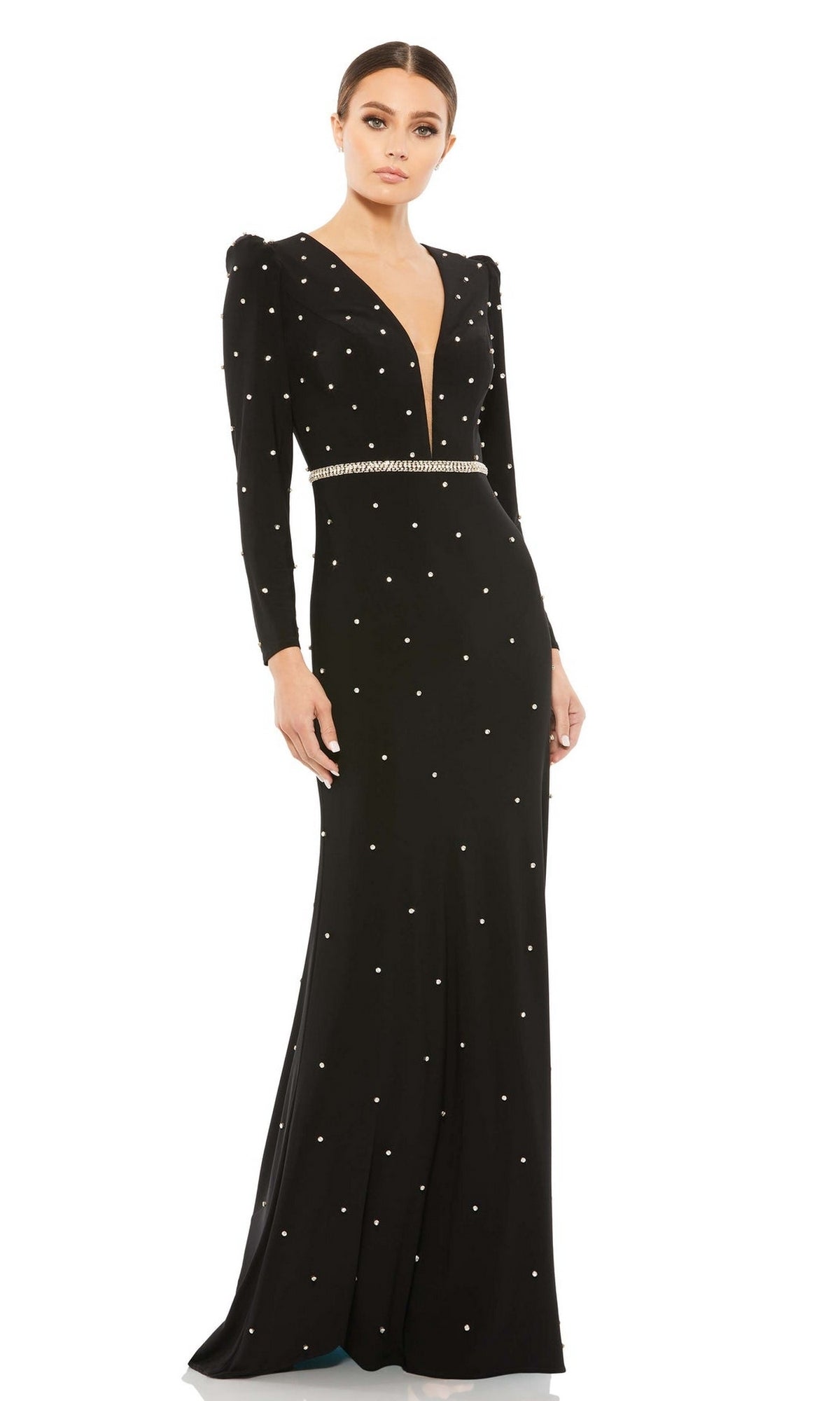 A woman wears the Long Formal Dress 67874 by Mac Duggal, featuring long sleeves, a plunging v-neckline, pearl-like embellishments, a jeweled belt, and an elegant floor-length design.